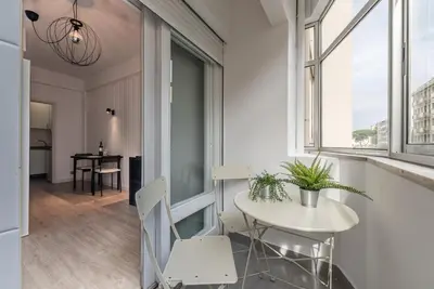 a small white table and chairs in a room with windows at GuestReady - Music Flats 2 in Porto