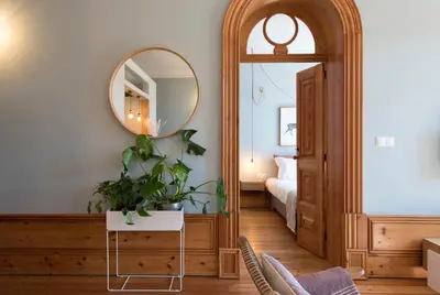 a bedroom with a mirror and a table with a plant at Cardosas Palace Apartment in Porto