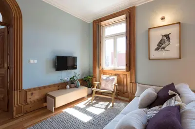 a living room with a couch and a window at Cardosas Palace Apartment in Porto