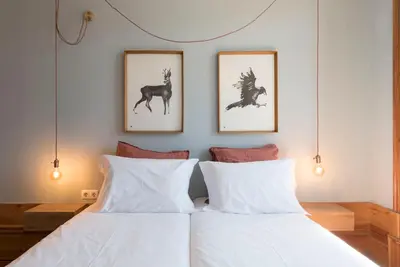 two beds in a bedroom with two pictures on the wall at Cardosas Palace Apartment in Porto