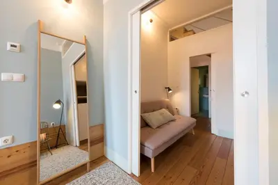 a living room with a couch and a mirror at Cardosas Palace Apartment in Porto