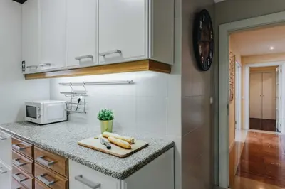 a kitchen with a cutting board on a counter at Spacious 1BR with Parking in Quiet Area in Vila Nova de Gaia