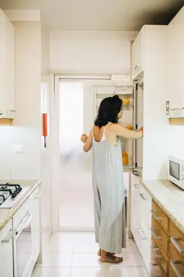 a woman in a kitchen looking into a refrigerator at Spacious 1BR with Parking in Quiet Area in Vila Nova de Gaia