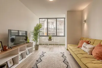 a living room with a couch and a tv at Travel and Live Apartments in Porto