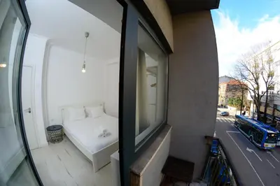 a bedroom with a white bed on a balcony at Travel and Live Apartments in Porto