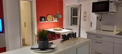 a kitchen with red walls and a white counter top at Downtown Porto Spot - 2 bedroom Apartment in Porto