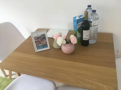 a table with bottles of wine and a vase with flowers at Porta de São Bento in Porto