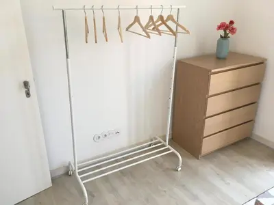 a clothes rack and a dresser in a room at Porta de São Bento in Porto