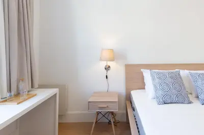 a bedroom with a white bed and a night stand at GuestReady - Costa Cabral Guesthouse in Porto