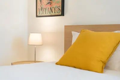 a yellow pillow sitting on top of a bed at GuestReady - Costa Cabral Guesthouse in Porto