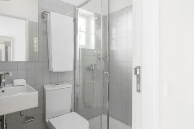 a bathroom with a shower and a toilet and a sink at GuestReady - Costa Cabral Guesthouse in Porto