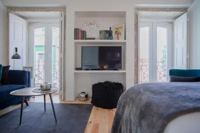 a bedroom with a bed and a tv and a couch at Liiiving in Porto - Cozy & Chic Downtown in Porto