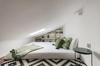 a white bedroom with a bed and a table at Oak Valley Flats Porto Santa Catarina in Porto