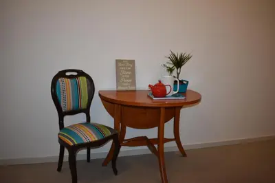 a wooden table with a chair and a table with a cup at Casa Barão Forrester in Porto