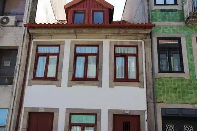 a building with red windows on top of it at Casa Barão Forrester in Porto