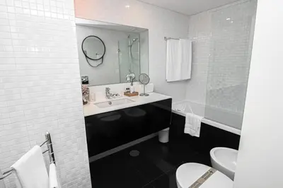 a bathroom with a sink and a toilet and a mirror at Douro Destilaria Residence by Porto City Hosts in Vila Nova de Gaia