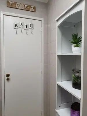 a white bathroom with a white door and a shelf at Ninho Jardim do Morro in Vila Nova de Gaia