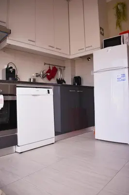 a kitchen with white appliances and white cabinets at Terraço da Boavista in Porto