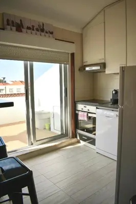 a kitchen with a large window and a refrigerator at Terraço da Boavista in Porto