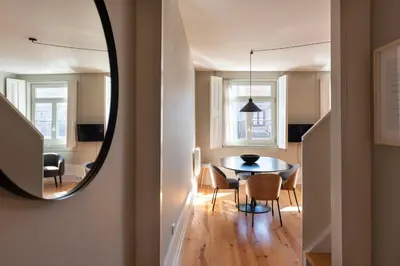 a dining room with a table and chairs and a mirror at Cedofeita Deluxe Apartment 3F in Porto