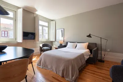 a bedroom with a bed and a table and chairs at Cedofeita Deluxe Apartment 3F in Porto