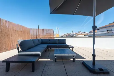 a blue couch and two tables and an umbrella at Cedofeita Deluxe Apartment 3F in Porto