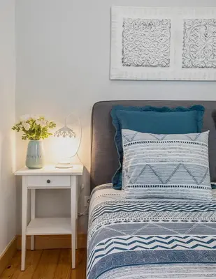 a bedroom with a large bed with blue pillows at Je T'aime Porto Sweet Rooms in Vila Nova de Gaia
