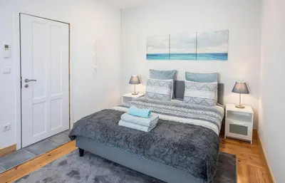 a bedroom with a bed and two tables and a window at Je T'aime Porto Sweet Rooms in Vila Nova de Gaia