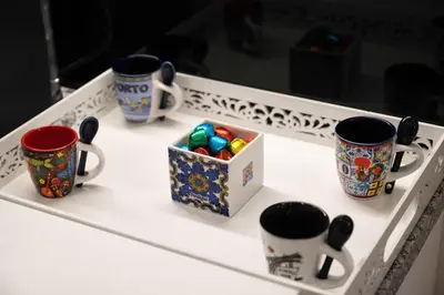 a table with four coffee cups and a box of crackers at Refugio in Porto