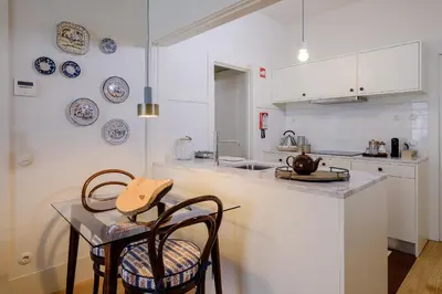 a kitchen with a table and two chairs and a counter at BOUTIQUE Rentals-Flores Plaza in city historical center in Porto