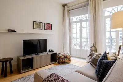 a living room with a couch and a television at BOUTIQUE Rentals-Flores Plaza in city historical center in Porto