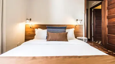 a bedroom with a large white bed with wooden headboard at YOUROPO - Santa Catarina in Porto