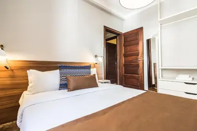 a bedroom with a large white bed and a television at YOUROPO - Santa Catarina in Porto