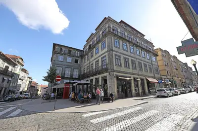 a large building on a city street with people sitting outside at FLH Porto Spacious Flat in Porto