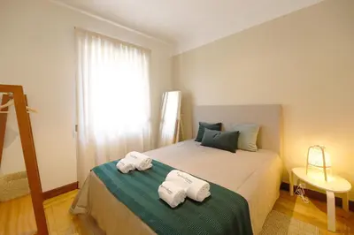 a bedroom with a bed with towels on it at FLH Porto Spacious Flat in Porto