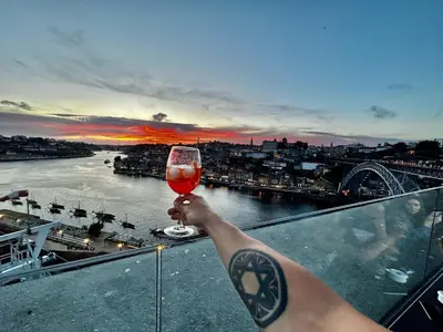 a person holding up a glass of wine on a balcony at Apartamento Lar doce Lar Porto in Vila Nova de Gaia