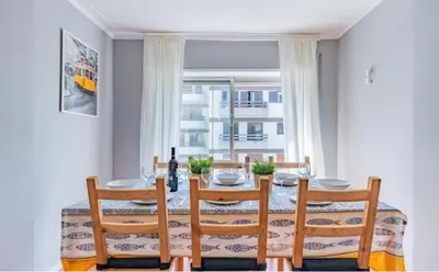 a dining room with a table and chairs and a window at Apartamento Lar doce Lar Porto in Vila Nova de Gaia