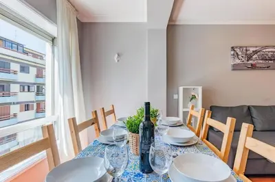 a dining room table with plates and a bottle of wine at Apartamento Lar doce Lar Porto in Vila Nova de Gaia