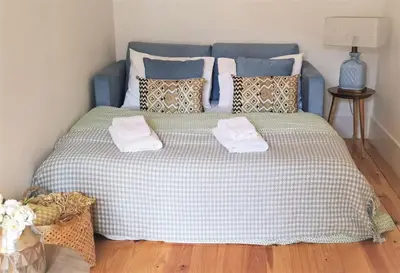 a blue bed with two towels on top of it at Porto Belo Sao Bento Apartment in Porto