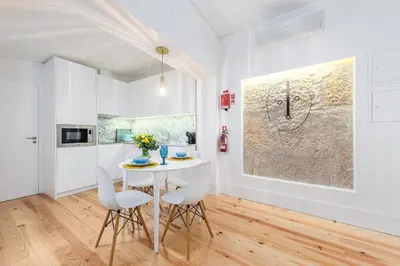 a white dining room with a white table and chairs at Porto Belo Sao Bento Apartment in Porto