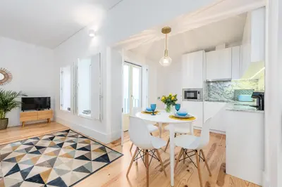 a kitchen and dining room with a white table and chairs at Porto Belo Sao Bento Apartment in Porto