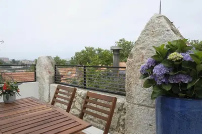 a table and chairs on a balcony with flowers at Oporto Wall Apartments in Porto
