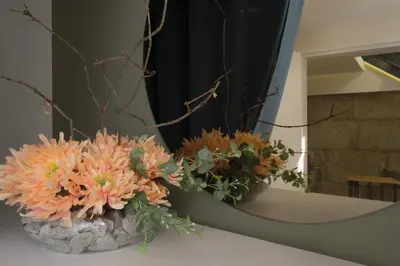 a vase of flowers sitting on a table in front of a mirror at Oporto Wall Apartments in Porto