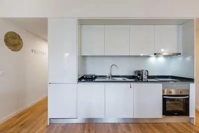 a kitchen with white cabinets and a sink at GuestReady - Bay Watch in Porto