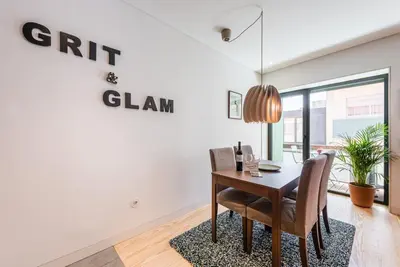 a dining room with a table and chairs and a sign that reads gift clan at GuestReady - Grit & Glam in Porto