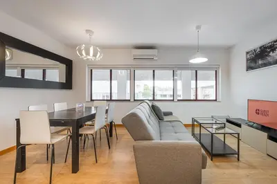 a living room with a couch and a table and chairs at GuestReady - Paragon in Porto in Porto