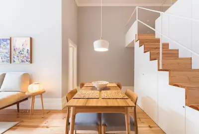 a dining room with a table and a staircase at Tripas-Coração, Santa Teresa in Porto