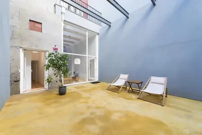 a room with two chairs and a table and a plant at Tripas-Coração, Santa Teresa in Porto
