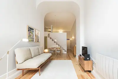 a living room with a couch and a staircase at Tripas-Coração, Santa Teresa in Porto