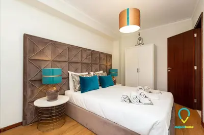 a bedroom with a large bed with blue pillows at Camilo Apartment in Porto